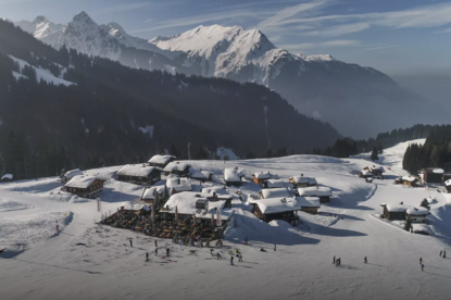 Gut besuchte Sonnenterrasse des Vermala Wirt im Winter mit Après-Ski Stimmung, Skifahrern und Blick auf die verschneiten Berge der Silvretta Montafon.